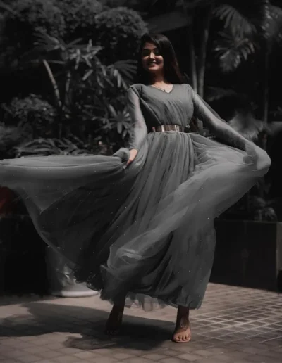 Flowing grey tulle maxi dress with long sleeves and a metallic belt.