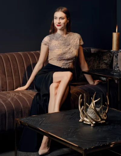 Elegant woman in a sophisticated top and skirt, showcasing luxury apparel manufacturing.