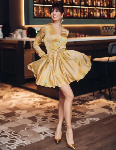Fashionable gold patterned mini dress, a testament to luxury garment manufacturing expertise in the USA.