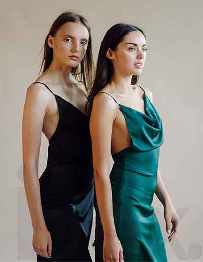 Two women wearing elegant luxury dresses, showcasing premium craftsmanship by Ibex Fashion, a top luxury clothing manufacturer in the USA.